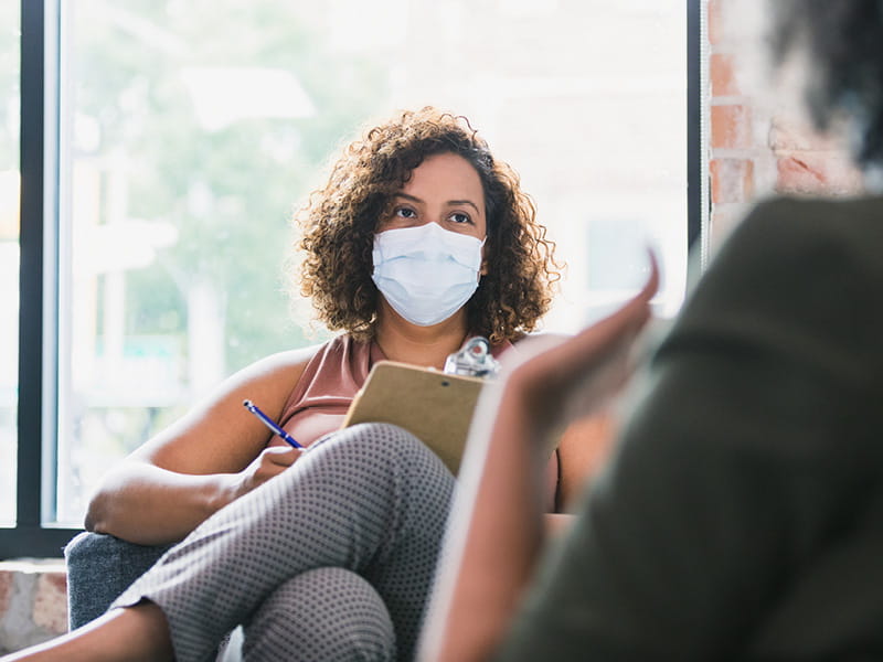 a patient and provider talking with masks on