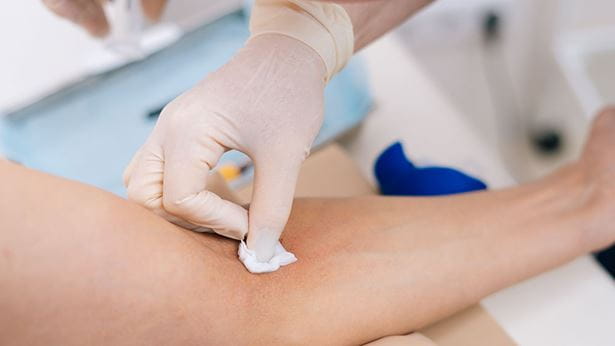 A woman getting her blood drawn at home.